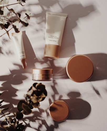 Cosmetic tubes and jars with metallic bronze caps styled with natural shadows, symbolizing MSM Beauty Solutions’ role in bridging brand founders, formulators, and packaging suppliers to oversee production, maintain quality, and deliver market-ready beauty launches